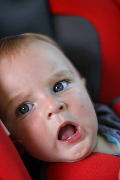 Ett litet nyfött barn i en bilstol. barnens säkerhet. Skydd av barn. Säkerhetsbälten. — Stockfoto