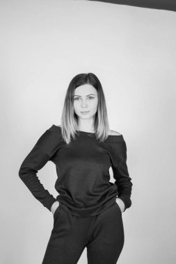 Hafif bir arkaplanda örülü takım elbiseli genç ve zayıf bir kız. Şefkat, kadınlık.