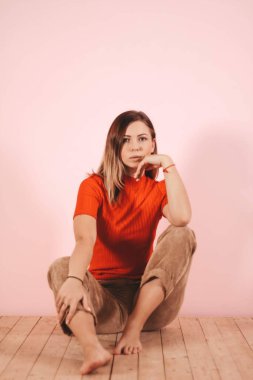 Hafif bir arkaplanda örülü takım elbiseli genç ve zayıf bir kız. Şefkat, kadınlık.