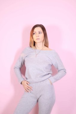 Hafif bir arkaplanda örülü takım elbiseli genç ve zayıf bir kız. Şefkat, kadınlık.