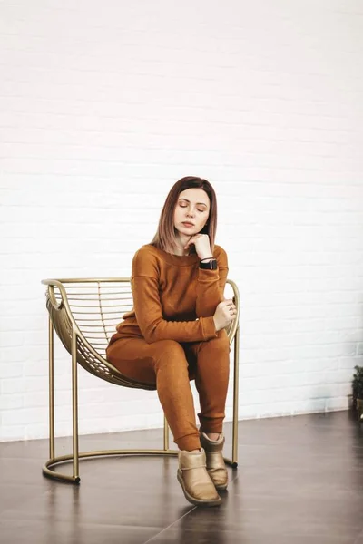 Young thin girl in a knitted suit on a light background. Tenderness, femininity. — Stock Photo, Image