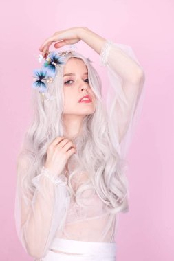 Pembe arka planda beyaz elbiseli sarışın kız.