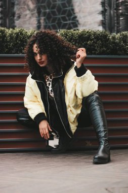 Kıvırcık saçlı, parlak makyajlı bir kız. ilginç çokuluslu görünüm.