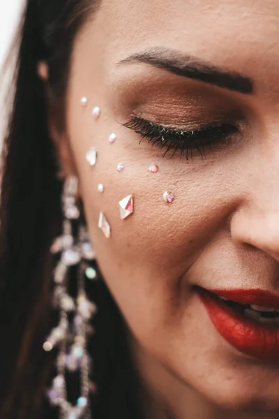 Close-up meisjes gezicht met sieraden stenen op haar wang, heldere make-up. — Stockfoto