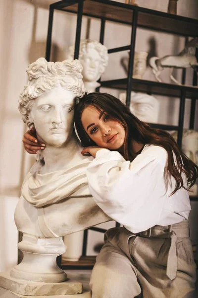 Een jonge sexy beeldhouwer. Meisje in de buurt van culturen. schoonheid, kunst. — Stockfoto