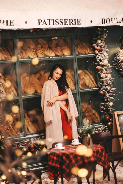 Nyårsfotografering av flickan. flicka i en röd kostym mot bakgrund av en vacker julgran — Stockfoto