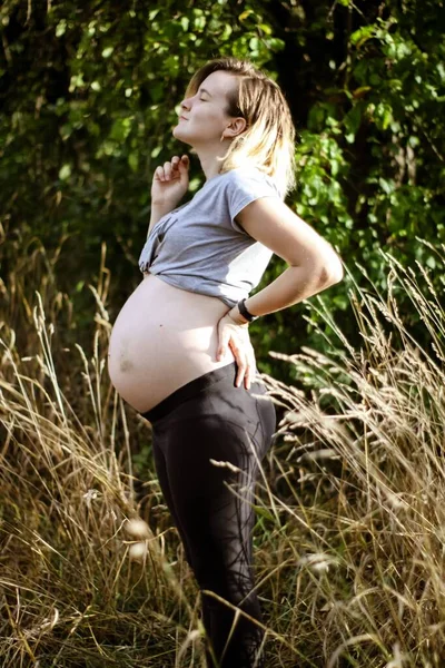 Fotocaça gravidez na natureza. jovem grávida com barriga grande na natureza. — Fotografia de Stock