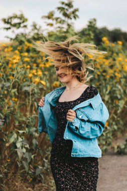 Sarı çiçek tarlasında enerjik, parlak bir kız. parlak makyaj, enerji.