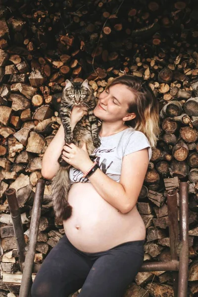 Kollarında kedisi olan hamile bir kız. Tasasız bir hayat. Mutlu hamilelikler. — Stok fotoğraf