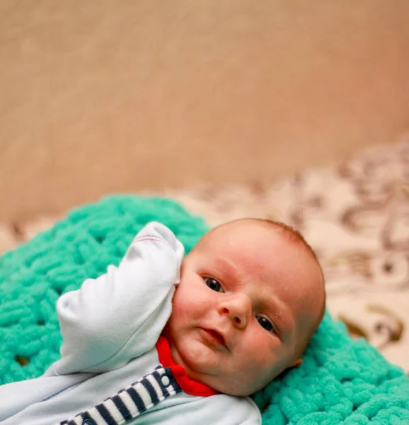 Kis újszülött fiú ül a pályán mákokkal fehér panama kalapban. — Stock Fotó