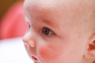 Yeni doğmuş küçük bir çocuğun yüzü. Yakından yanakları yuvarlak.