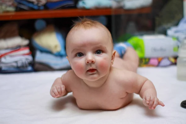 Egy újszülött fekszik a hasán. Pufók fiú. redők — Stock Fotó