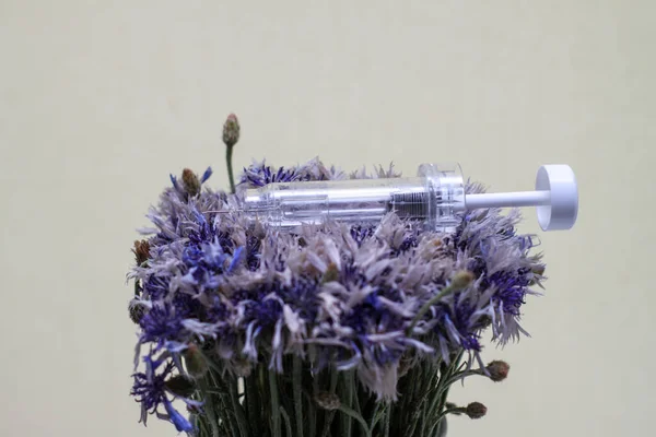 Σύριγγα σε λουλούδια. Καλλυντικές διαδικασίες. Ενέσιμα, ενέσεις. Ασθένειες, θεραπεία, ιατρική, εμβόλιο. — Φωτογραφία Αρχείου