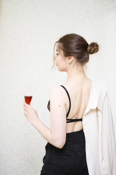 Hemmagjorda bilder på en flicka med ett glas vin i skjorta — Stockfoto