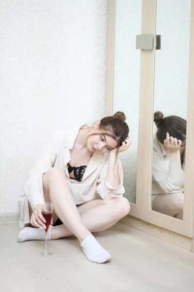 Düşünceli seksi kız evde bir kadeh şarapla.