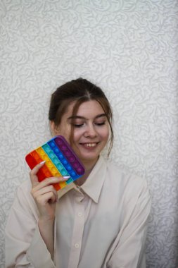 Neşeli kız pop müzik çalıyor. Stres önleyici, basit gamzeli, patlat.