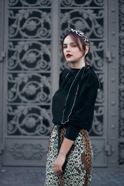 Büyük kapı panjurlarının arkasında zarif bir kadın. Sokak tarzı.