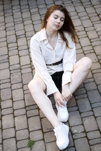 Sexy tenera ragazza seduta sulla pavimentazione lastre — Foto Stock