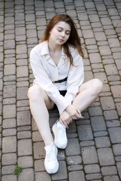 Sexy tenera ragazza seduta sulla pavimentazione lastre — Foto Stock