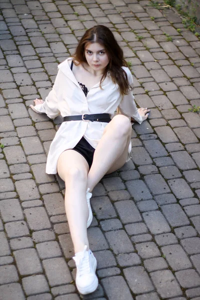 Сексуальна тендітна дівчина сидить на тротуарних плитах — стокове фото
