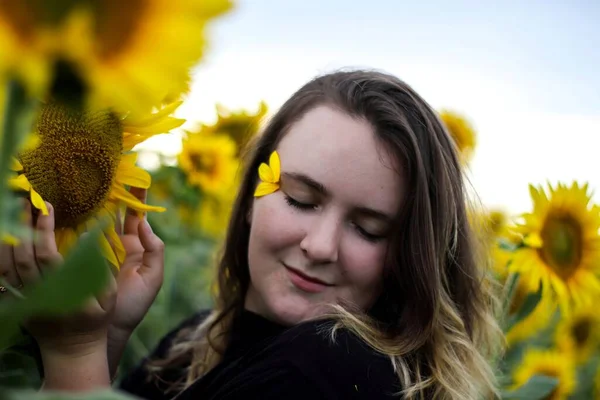 Junge brünette Mädchen in einem Feld von Sonnenblumen. Sommerabend. Romantischer Sommer. — Stockfoto