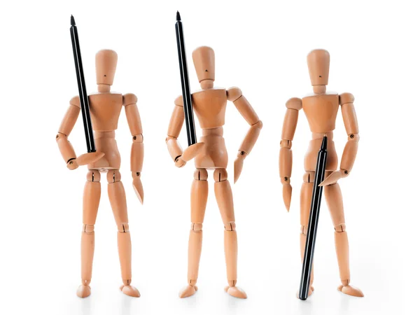 Três manequins de madeira segurando canetas guardas armados como — Fotografia de Stock