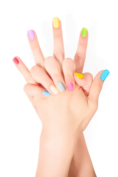 Handen met gekleurde nagels. Geïsoleerd op wit met knippen — Stockfoto