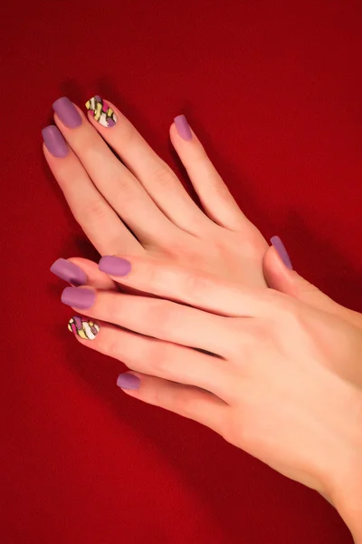 Mãos com manicure violeta — Fotografia de Stock