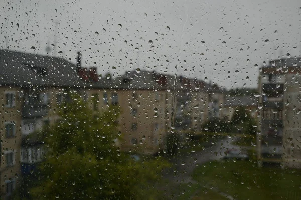 Regendruppels Het Raam Bewolkte Zomerdag Natte Huizen Achtergrond — Stockfoto