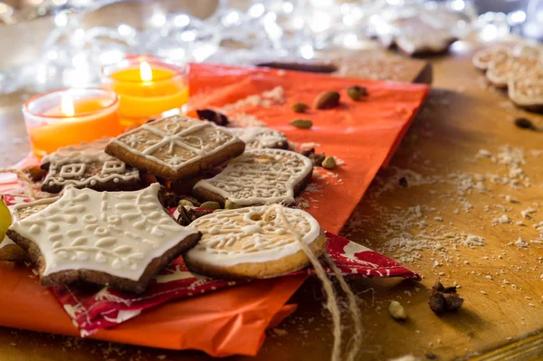 Biscoitos de Natal com velas em um fundo vermelho e de madeira — Fotografia de Stock