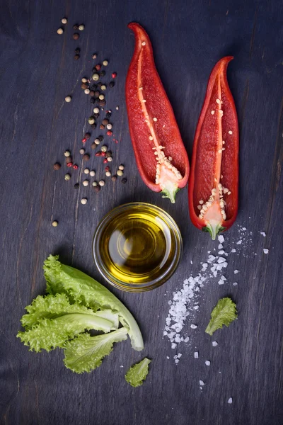 Ingredientes de la ensalada: pimiento rojo, lechuga, aceite de oliva sobre fondo rústico de madera. Verduras frescas, vista superior . — Foto de Stock