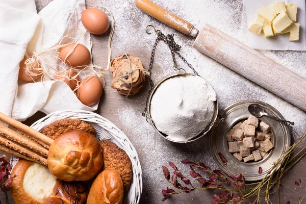 Backzutaten - Mehl, Butter, Eier, Zucker. gebackene Mehlspeisen: Brot, Kekse, Kuchen, Gebäck. Ansicht von oben. — Stockfoto