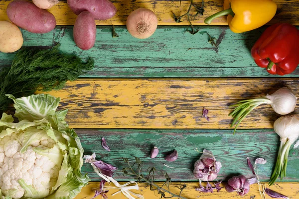 Healthy diet vegetable food frame. Fresh raw, Broccoli, potatoes, peppers and herbs on colorful wooden background. Copy space, above view. — Stock Photo, Image