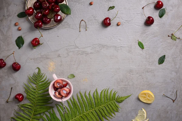 Sopra la testa di ciliegie rosse fresche, dessert clafouti su superficie grigia, in stile felce e limone. Copia spazio, vista dall'alto . — Foto Stock