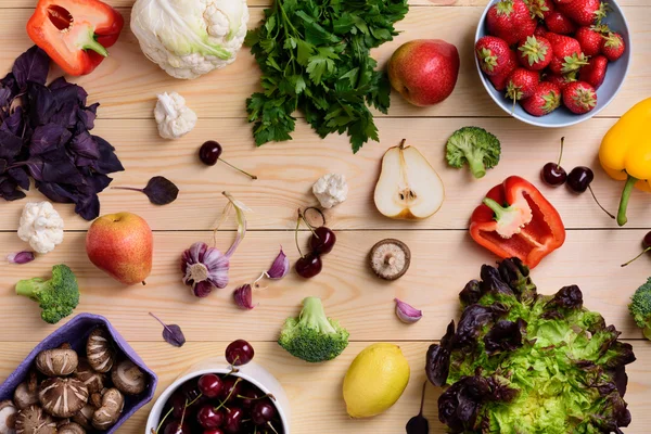 Variety of colorful fruits, vegetables and berries. Healthy diet concept. Vegetarian organic food set over wooden table. Top view. — Stock Photo, Image