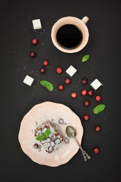 Fresh berries on tart cake, cup coffee, fresh cranberry and sugar cubes over black background. Top view. — Φωτογραφία Αρχείου