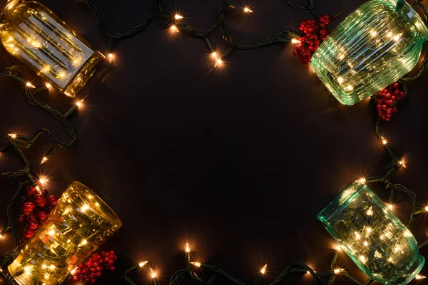 Nuevo año luces guirnalda en jarrones de vidrio como marco decorativo para el concepto de Navidad o tarjetas. Vista superior, espacio de copia . —  Fotos de Stock