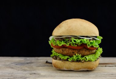 Taze burger falafel ve siyah zemin ve boşaltmak ile ahşap üzerine salata.