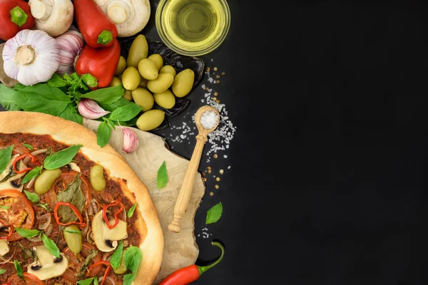 Pizza fraîche aux olives, tomates et champignons sur fond noir. Espace pour le texte, vue du dessus . — Photo