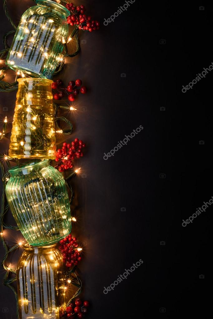 A Stack Of Vintage Vases With Warm String Lights On Dark