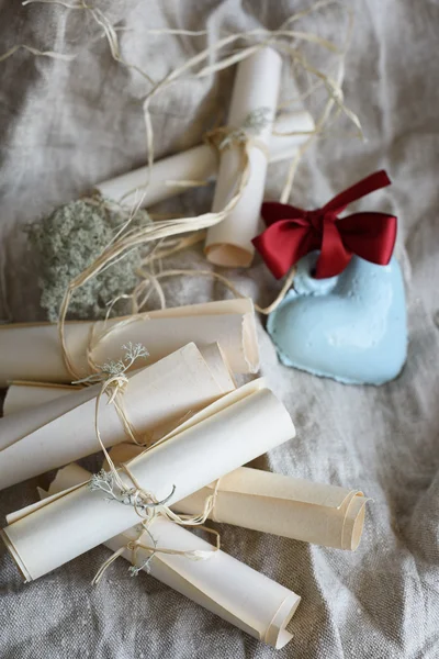 Bröllop vintage papper inbjudan rullar och blå keramik hjärta med röda bow på en säckväv. — Stockfoto