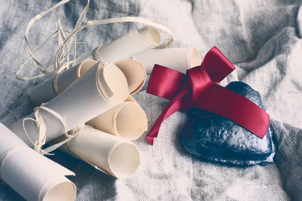 Valentinsherz mit karminrotem Band und Papierrollen auf rustikalem Stoffhintergrund. Vintage-Filtereffekt. — Stockfoto