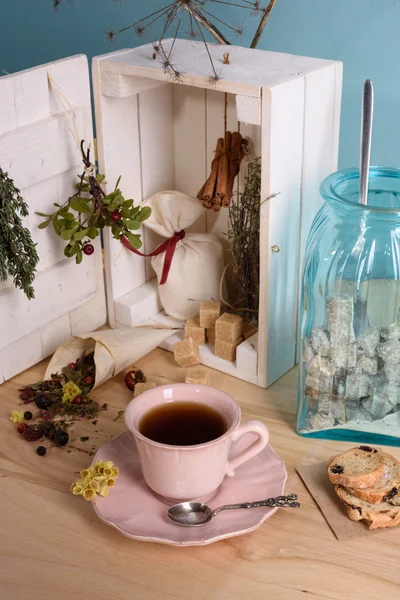 Tisana in tazza vintage. Scatola di legno piena di erbe, spezie e zucchero. sfondo turchese . — Foto Stock