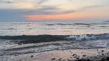 Gün batımında sıcak akşam ışığı ve sakin kıyı atmosferiyle Adriyatik kıyılarında deniz dalgaları kırılıyor.