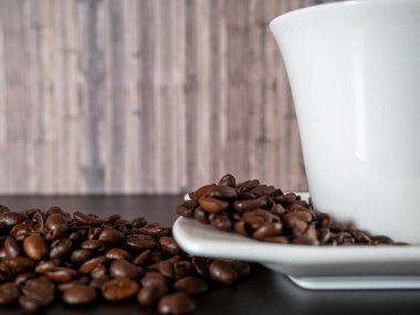 Bir fincan sıcak kahve ve kahve çekirdeği. Siyah arka planda sıcak kahve..