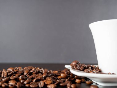 Bir fincan sıcak kahve ve kahve çekirdeği. Siyah arka planda sıcak kahve..