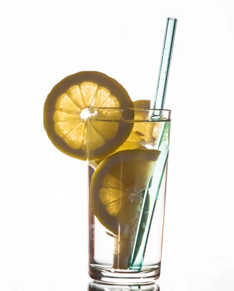 A glass of lemon drink with sliced lemon wedges. — Zdjęcie stockowe