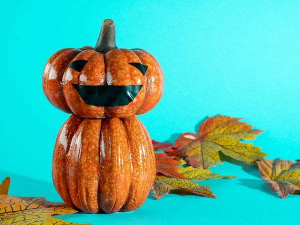 Feliz Halloween, calabaza y hojas sobre un fondo azul. — Foto de Stock