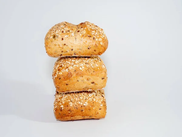 Pão assado embebido em sementes de gergelim e aveia isolado em fundo branco. — Fotografia de Stock