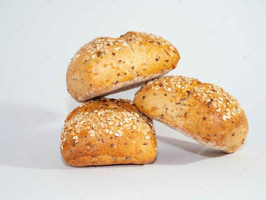 Baked bun soaked in sesame seeds and oatmeal isolated on white background. 